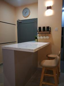 a kitchen with a counter and a clock on the wall at Bayu D'Awan Muslim Homestay Putrajaya in Putrajaya