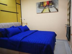 sypialnia z niebieską kołdrą na łóżku w obiekcie Bayu D'Awan Muslim Homestay Putrajaya w mieście Putrajaya