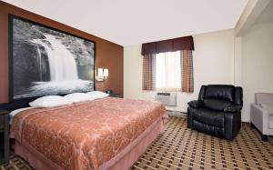 a hotel room with a bed and a chair at Super 8 by Wyndham Ashland in Ashland