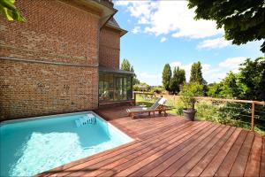 une terrasse en bois avec une piscine au-dessus d'une maison dans l'établissement Honfleur, Entre Terre & Estuaire, à La Rivière-Saint-Sauveur