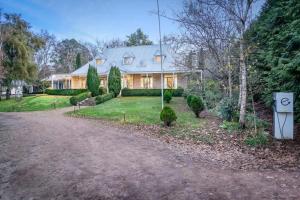 une maison avec une allée en face de celle-ci dans l'établissement Beechworth House, à Beechworth