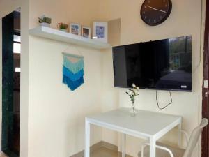 a white table and a tv in a room at 5 - Studio Velankanni Heights, Behaind Nanavati Hospital, Vile Parle by Connekt Homes in Mumbai