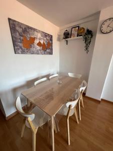 een eetkamer met een houten tafel en stoelen bij 3 Bedrooms Apt WITH THE SEA VIEW in Málaga