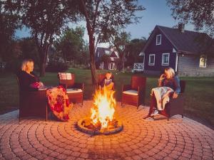 a group of people sitting around a fire pit at Lovely Tiny House in Kelmė