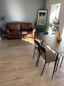 a living room with a couch and a table and chairs at Lovely Tiny House in Kelmė