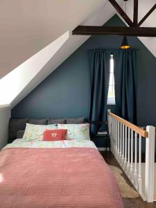 een slaapkamer met een bed en een blauwe muur bij Lovely Tiny House in Kelmė