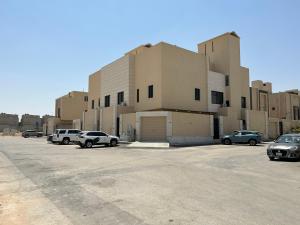 un estacionamiento con autos estacionados frente a un edificio en شقة فاخرة غرفة وصالة بالعارض ٢ en Riad