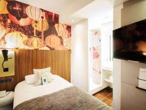 リヨンにあるメルキュール リヨン サントル プラザ レピュブリックのベッドルーム(ベッド1台、薄型テレビ付)