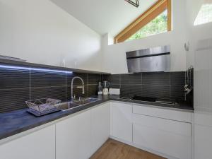 una cucina bianca con lavandino e finestra di Chalet moderne à Méribel : jacuzzi, sauna, 6 chambres, proche centre et navette - FR-1-565-55 a Les Allues