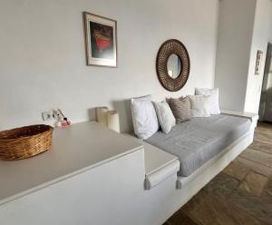 a bed in a room with a mirror on the wall at Sunny Stone Tinos House in Tinos