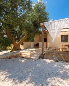 uma casa com uma árvore e um guarda-chuva branco em Residenza alla Battaglia em Villa Castelli