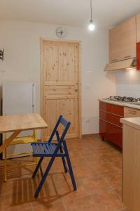 uma cozinha com uma mesa e uma cadeira azul em Residenza alla Battaglia em Villa Castelli