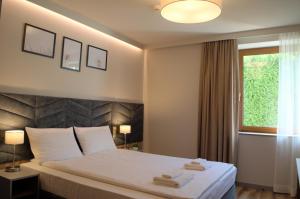 een slaapkamer met een bed met twee handdoeken erop bij Villa & Gospoda Krakowska in Kobiernice