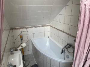 a small bathroom with a tub and a toilet at Penzion Kamenný Dvůr in Vimperk