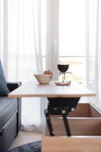 einen Tisch mit einer Schüssel Essen und einem Glas Wein in der Unterkunft Mirtilo Apartment in Oinófita