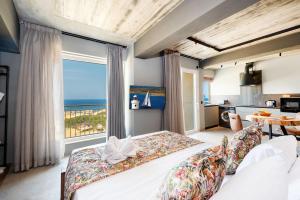 a bedroom with a bed with a view of the ocean at Salini Suites in Żebbuġ