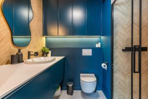 a blue bathroom with a toilet and a sink at Golden Seaside Beach - 200m from the sea in Gdańsk