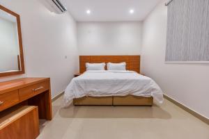 ein Schlafzimmer mit einem Bett und einem TV in der Unterkunft La Casa Apartment in Riad
