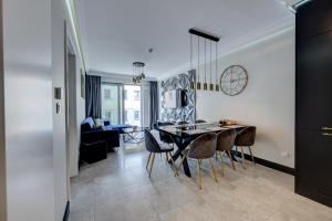 a dining room and living room with a table and chairs at MALAGA APARTAMENTY BALTICUS in Międzyzdroje