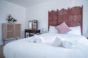 a bedroom with a white bed with towels on it at Swn Y Mor - 4 Bedroom Holiday Home - Llanelli in Llanelli