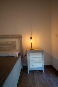 a bedroom with a bed and a dresser with a lamp on it at California Apartament Dueñas in Seville