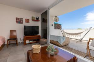 ein Wohnzimmer mit Blick auf den Strand in der Unterkunft Santa Luzia Green Apartment in Santa Luzia