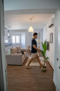 a man walking through a living room with a plant at California Apartament Dueñas in Seville