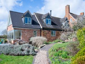 a brick house with blue windows and a yard at Pass the Keys Peaceful Countryside Residence in Pershore