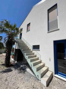 a building with a staircase next to a palm tree at Sea view 2 bedroom apartment in Portorož