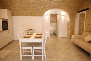 een keuken en eetkamer met een witte tafel en stoelen bij Casa di Gio in Scicli