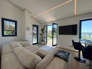 a living room with a large couch and a television at Sea view 2 bedroom apartment in Portorož