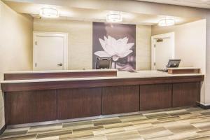 a lobby with a reception desk with a flower on the wall at Howard Johnson by Wyndham Sacramento Downtown in Sacramento