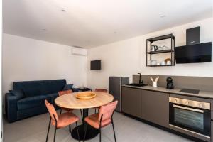 a kitchen and living room with a table and a couch at Savadè Cefalù in Cefalù