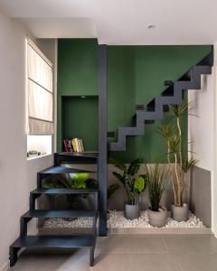 a staircase in a living room with plants at Savadè Cefalù in Cefalù