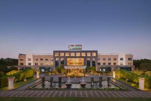 a large building with a sign on top of it at Radisson Hotel Kandla in Gandhidham