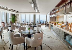a restaurant with tables and chairs and windows at The Westin Pazhou in Guangzhou