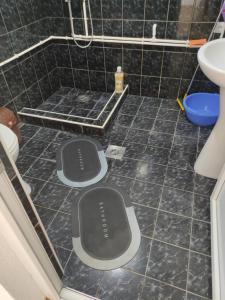 a bathroom with two mats on a tiled floor at Villa 17 in Gevgelija