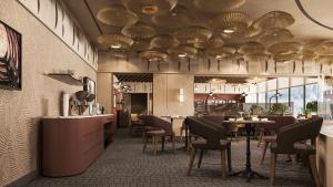 Park Inn by Radisson, Riyadh في الرياض: مطعم به طاولات وكراسي واضاءات سقف كبيره