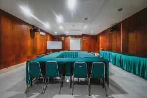 a conference room with a blue table and chairs at RedDoorz Plus At Megamendung Puncak Bogor in Bogor