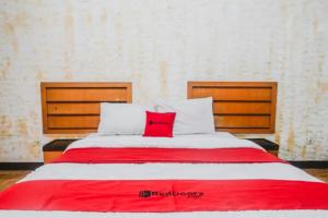 a large bed with a red pillow on it at RedDoorz Plus at Neo Asri Hotel Megamendung Puncak Bogor in Bogor +5 photos
