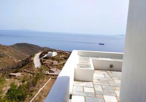 a view of the ocean from the balcony of a house at Sunny Stone Tinos House in Tinos +16 photos