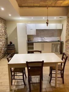 uma cozinha com mesa e cadeiras e uma cozinha com frigorífico em Taverna Bucciante em Fossacesia