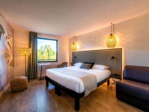 ein Hotelzimmer mit einem großen Bett und einem Fenster in der Unterkunft ibis Styles Rennes Cesson in Cesson-Sévigné
