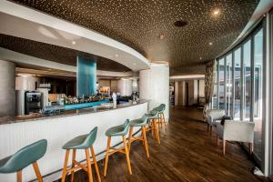 a bar in a restaurant with green stools at Southern Sun Elangeni & Maharani in Durban