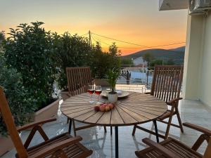 a wooden table with wine glasses and fruit on a balcony at Marble's Residence in Argostoli