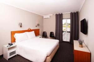 Habitación de hotel con cama y ventana en Estremoz Hotel en Estremoz