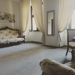 ein Wohnzimmer mit einem Bett und einem Spiegel in der Unterkunft Pałac Chichy 