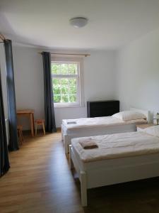 pokój z 3 łóżkami i oknem w obiekcie Zielony Zakątek w mieście Krynki