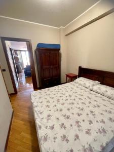 a bedroom with a bed with a floral bedspread at CASE PUGLISI in Acitrezza