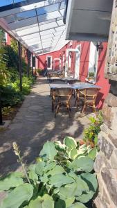 un patio con mesa, bancos y plantas en Rolfs Country House en Baltimore